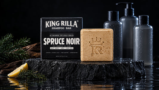 King Rilla Spruce Noir shampoo bar and carton with empty plastic bottles in a dark background.