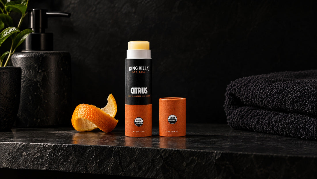 King Rilla Citrus lip balm on a charcoal shelf with a citrus peel accent.