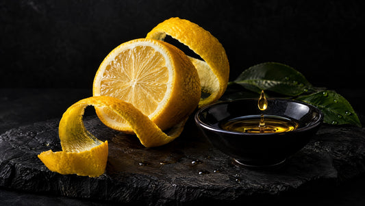 Lemon peel, a cut lemon and an oil droplet in a dark ingredient composition.