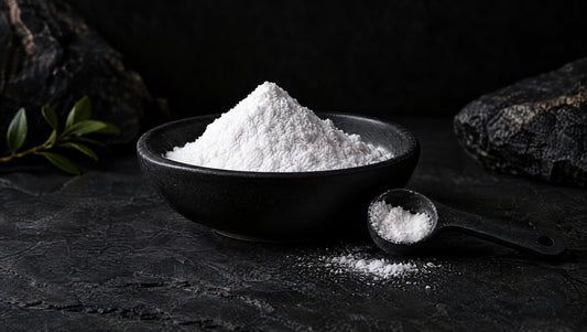 Fine sodium bicarbonate powder and a black measuring spoon on graphite stone.