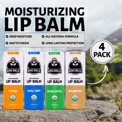 Four King Rilla moisturizing lip balm packages on a rock with a scenic background.