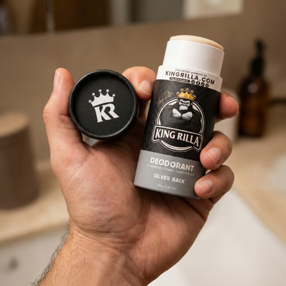 Hand holding a King Rilla deodorant stick and cap in a bathroom setting