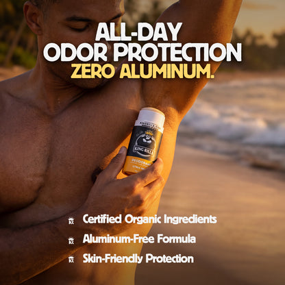 Man applying King Billy deodorant on his arm with beach background