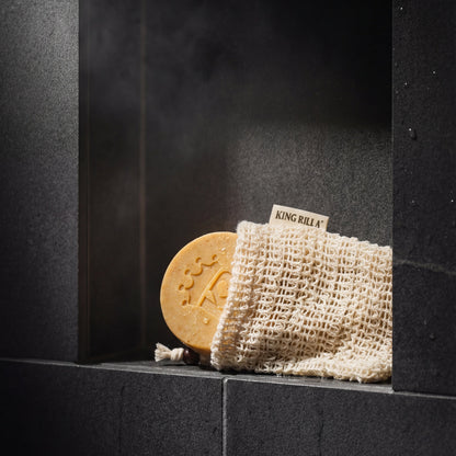 Bar of soap and washcloth on a dark surface with 'KING RILEY' branding.