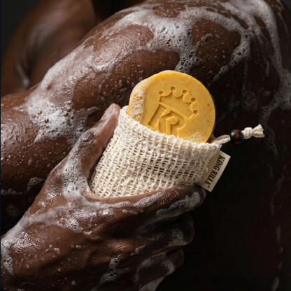 Hand holding a bar of soap with a brand logo against a dark background