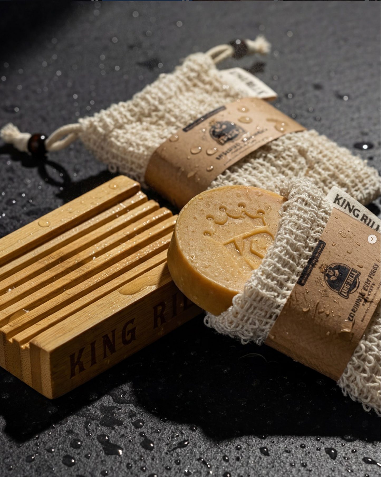 Bar of soap with a wooden soap dish and washcloth on a dark surface