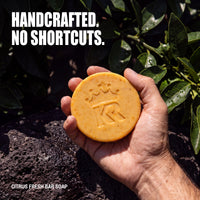 Hand holding a substantial handcrafted Citrus Fresh soap bar