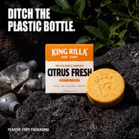 Citrus Fresh soap and plastic-free carton beside discarded plastic bottles