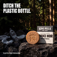 Spruce Noir soap and plastic-free carton beside discarded plastic bottles
